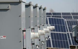 Close-up of electrical boxes and solar panels harnessing solar energy outdoors.